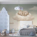 Une chambre d'enfant avec un papier peint doux représentant un ours endormi sur un nuage, créant une atmosphère paisible et rêveuse.