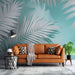 Un salon moderne avec un papier peint tropical aux grandes feuilles grises sur fond turquoise, créant une ambiance fraîche et apaisante.