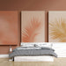 Une chambre moderne avec un papier peint aux teintes douces, présentant des motifs de feuilles tropicales dans des tons orangés et dorés, créant une atmosphère chaleureuse et accueillante.