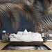 Une chambre moderne avec un papier peint tropical représentant de grandes feuilles de palmier dorées sur fond bleu nuit, créant une atmosphère chaleureuse et apaisante.