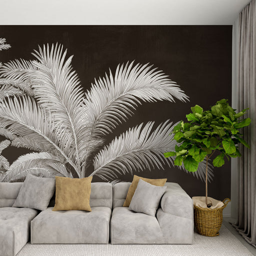 Un salon moderne avec un papier peint représentant de grandes feuilles de palmier blanches sur fond brun, créant une atmosphère élégante et chaleureuse.