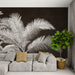 Un salon moderne avec un papier peint représentant de grandes feuilles de palmier blanches sur fond brun, créant une atmosphère élégante et chaleureuse.