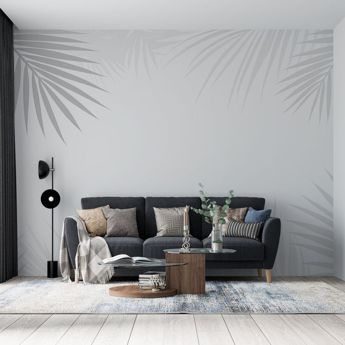 Un salon moderne avec un papier peint aux motifs de feuilles de palmier en ton sur ton sur fond gris, créant une ambiance apaisante et élégante.