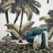 Un salon moderne avec un papier peint tropical représentant des palmiers stylisés en noir et or sur fond blanc, créant une ambiance relaxante et chaleureuse.