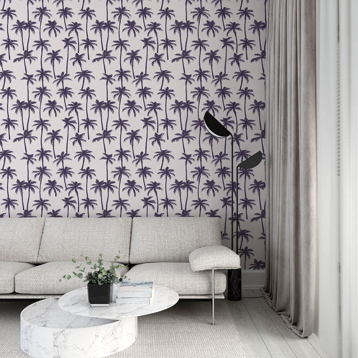 Un salon moderne avec un papier peint tropical mauve illustrant des palmiers sur fond clair, créant une ambiance estivale et relaxante.