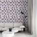 Un salon moderne avec un papier peint tropical mauve illustrant des palmiers sur fond clair, créant une ambiance estivale et relaxante.