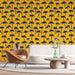 Un salon moderne avec un papier peint tropical jaune vif orné de palmiers noirs, créant une ambiance estivale et dynamique.