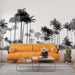Un salon moderne avec un papier peint représentant des silhouettes de palmiers noirs sur fond blanc, créant une ambiance tropicale et élégante.