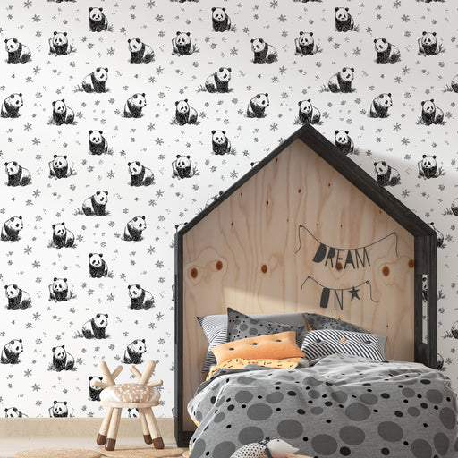 Une chambre enfantine avec un papier peint illustré de pandas en noir et blanc sur fond clair, créant une ambiance ludique et chaleureuse.