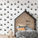 Une chambre enfantine avec un papier peint illustré de pandas en noir et blanc sur fond clair, créant une ambiance ludique et chaleureuse.