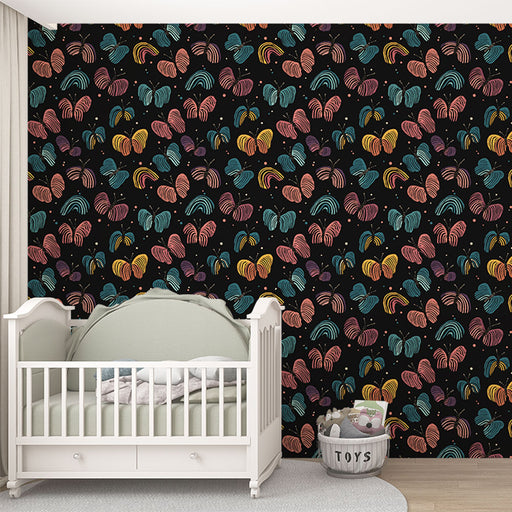 Une chambre d'enfant avec un papier peint coloré aux motifs de feuilles stylisées sur fond noir, créant une ambiance ludique et chaleureuse.