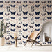 Une pièce lumineuse avec un papier peint floral et papillon aux teintes bleu marine et rose, créant une atmosphère douce et naturelle.