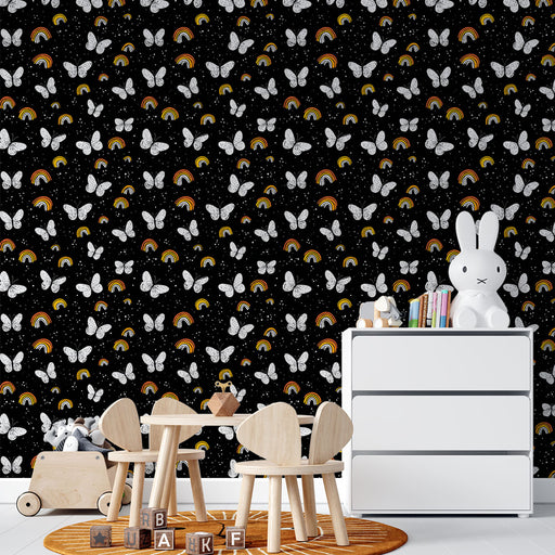 Une chambre d'enfant avec un papier peint noir orné de papillons blancs et d'arc-en-ciel colorés, créant une atmosphère ludique et joyeuse.