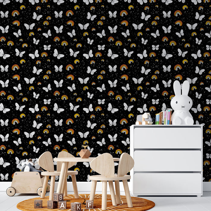 Une chambre d'enfant avec un papier peint noir orné de papillons blancs et d'arc-en-ciel colorés, créant une atmosphère ludique et joyeuse.