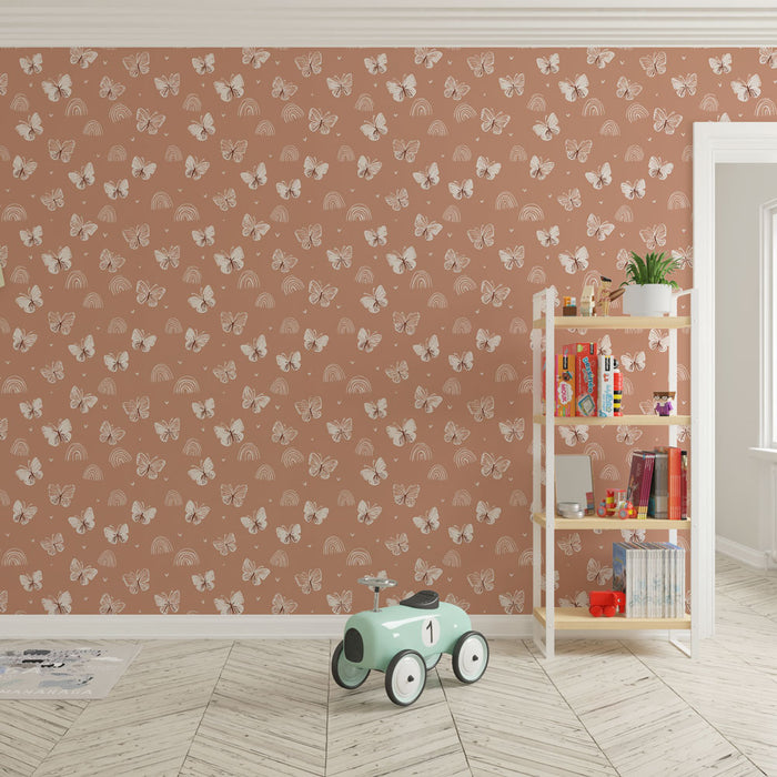 Une chambre d'enfant avec un papier peint terracotta orné de papillons et d'arcs-en-ciel, créant une ambiance joyeuse et ludique.