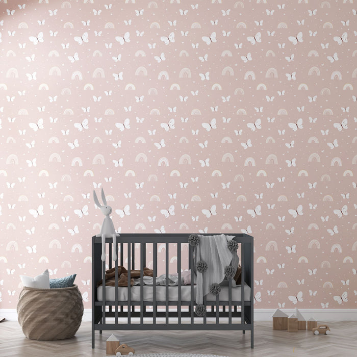 Une chambre d'enfant avec un papier peint pastel orné de papillons blancs et d'arcs-en-ciel, créant une atmosphère douce et joyeuse.