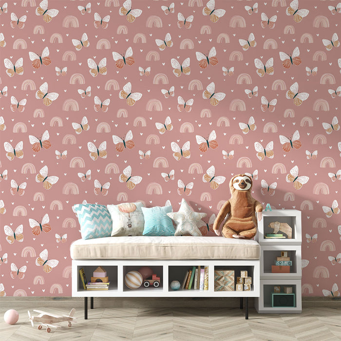 Une chambre d'enfant avec un papier peint rose orné de papillons et d'arcs-en-ciel créant une atmosphère joyeuse et ludique.