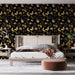 Une chambre élégante avec un papier peint noir orné de motifs de feuilles et de papillons dorés, créant une atmosphère sophistiquée et chaleureuse.