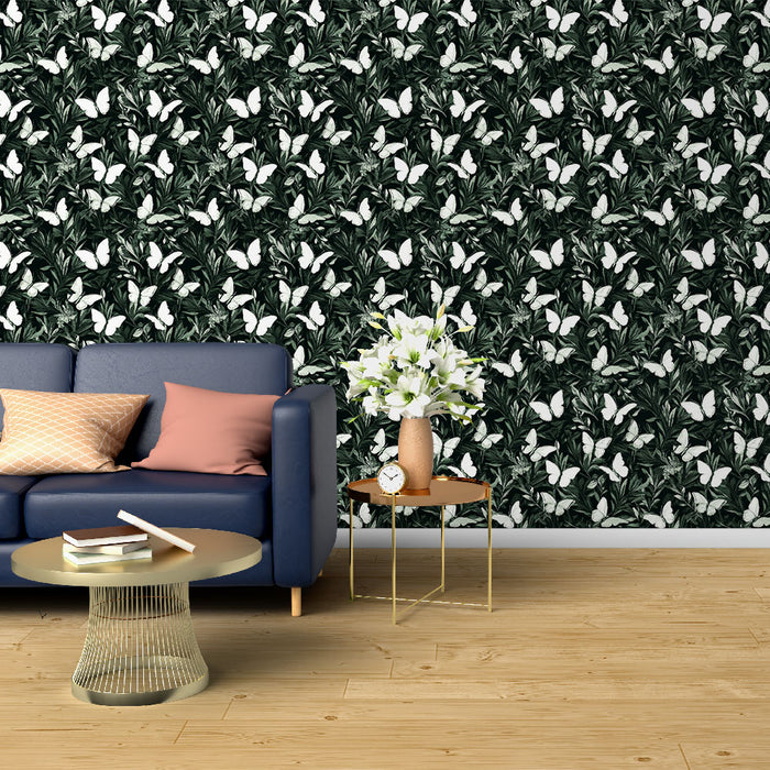 Un salon moderne avec un papier peint tropical noir orné de motifs de feuilles vertes et de papillons blancs, créant une ambiance vivante et apaisante.