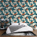 Une chambre moderne avec un papier peint tropical aux motifs de feuilles et de papillons dans des teintes turquoise, orange et crème, créant une ambiance vivante et apaisante.