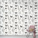 Une chambre élégante avec un papier peint noir et blanc illustrant des papillons et des plantes délicates, créant une ambiance artistique et apaisante.