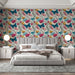 Une chambre élégante avec un papier peint floral vibrant aux motifs de fleurs roses, jaunes et bleues, créant une ambiance joyeuse et accueillante.
