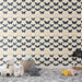 Une chambre d'enfant avec un papier peint aux motifs de papillons navy et beige sur fond clair, créant une ambiance douce et ludique.