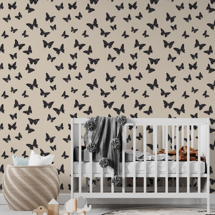 Une chambre d'enfant avec un papier peint beige orné de motifs de papillons noirs, créant une atmosphère douce et poétique.