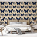 Une chambre élégante avec un papier peint représentant des papillons bleus sur fond beige, agrémenté de motifs de feuillage, créant une ambiance vivante et apaisante.