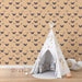 Une chambre d'enfant avec un papier peint beige orné de motifs de papillons noirs, créant une atmosphère douce et rêveuse.