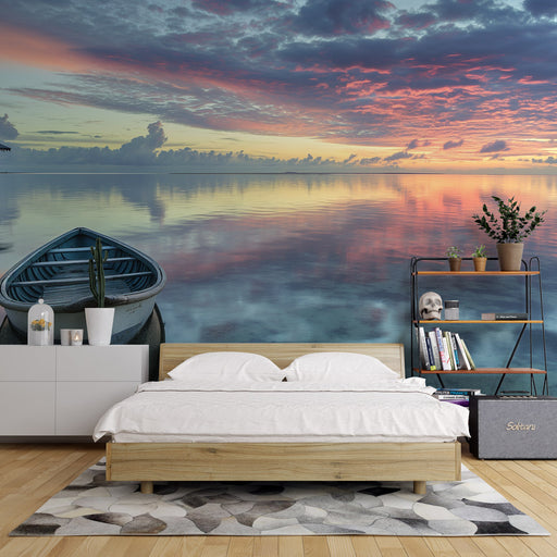 Une chambre apaisante avec un papier peint représentant un paysage marin au coucher de soleil, mêlant des teintes de bleu, rose et violet, créant une atmosphère sereine et relaxante.
