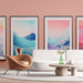 Un salon contemporain avec un papier peint rose pastel, créant une ambiance douce et chaleureuse, agrémenté de tableaux aux motifs de montagnes aux teintes apaisantes.