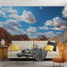 Une pièce de salon moderne avec un papier peint représentant un paysage désertique aux teintes ocres et un ciel bleu parsemé de nuages, créant une atmosphère apaisante et inspirante.