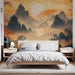 Une chambre apaisante avec un papier peint représentant des montagnes brumeuses aux teintes chaudes d'orange et de bleu, créant une atmosphère zen et sereine.