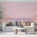 Un salon moderne avec un papier peint pastel représentant un paysage côtier minimaliste, évoquant une ambiance douce et apaisante.