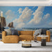 Un salon contemporain avec un papier peint représentant un paysage côtier apaisant, où des vagues se brisent contre des falaises sous un ciel bleu parsemé de nuages.