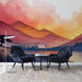Une pièce moderne avec un papier peint illustrant des montagnes aux teintes chaudes de rose et orange, créant une atmosphère sereine et artistique.
