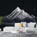 Un salon moderne avec un papier peint représentant des montagnes stylisées en lignes blanches sur fond noir, créant une ambiance à la fois élégante et apaisante.