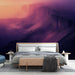 Une chambre moderne avec un papier peint représentant des paysages montagneux aux teintes violettes et orangées, créant une atmosphère apaisante et rêveuse.