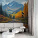 Un salon moderne avec un papier peint représentant un paysage montagnard automnal, mêlant des teintes orange et vert, créant une atmosphère chaleureuse et apaisante.