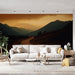 Un salon moderne avec un papier peint représentant un paysage montagneux au coucher de soleil, aux teintes chaudes et apaisantes créant une atmosphère sereine.