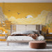 Une chambre élégante avec un papier peint mural aux teintes jaunes représentant un paysage asiatique, mêlant montagnes, nuages et oiseaux, créant une ambiance sereine et poétique.