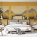 Une chambre élégante avec un papier peint représentant un paysage asiatique apaisant, avec un pont délicat et des montagnes dorées en arrière-plan.