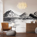 Une pièce moderne avec un papier peint illustrant des montagnes et des rochers en noir et blanc, créant une atmosphère apaisante et artistique.