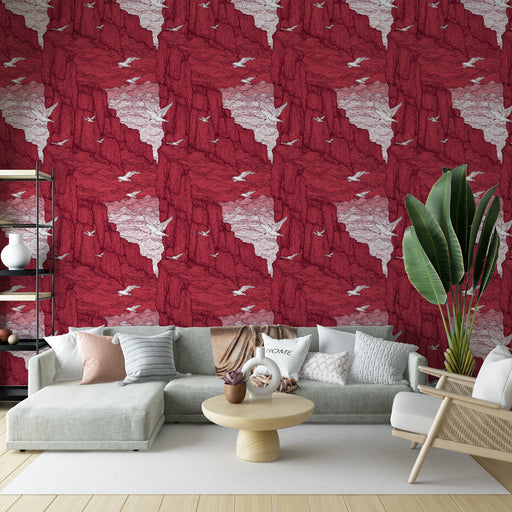 Un salon contemporain avec un papier peint aux motifs de falaises rouges et blanches ornées de silhouettes d'oiseaux, créant une atmosphère dynamique et chaleureuse.