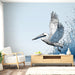 Une pièce lumineuse avec un papier peint illustrant un pélican en plein vol, entouré de vagues stylisées dans des teintes de bleu, créant une ambiance marine et apaisante.