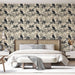 Une chambre élégante avec un papier peint tropical beige illustrant des perroquets noirs et des feuillages, créant une ambiance vivante et chaleureuse.