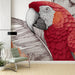 Une pièce moderne avec un papier peint représentant un perroquet rouge stylisé et des feuilles exotiques, créant une ambiance vibrante et tropicale.