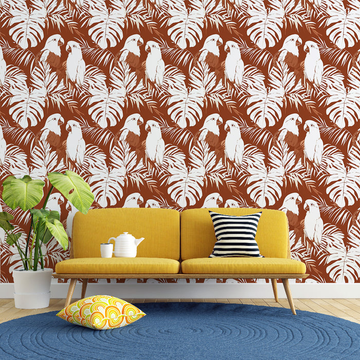 Un salon moderne avec un papier peint tropical rouge brique illustrant des perroquets blancs et des feuilles de palmier, créant une ambiance chaleureuse et vivante.