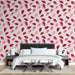 Une chambre élégante avec un papier peint floral aux pétales roses et rouges sur fond clair, créant une atmosphère douce et romantique.